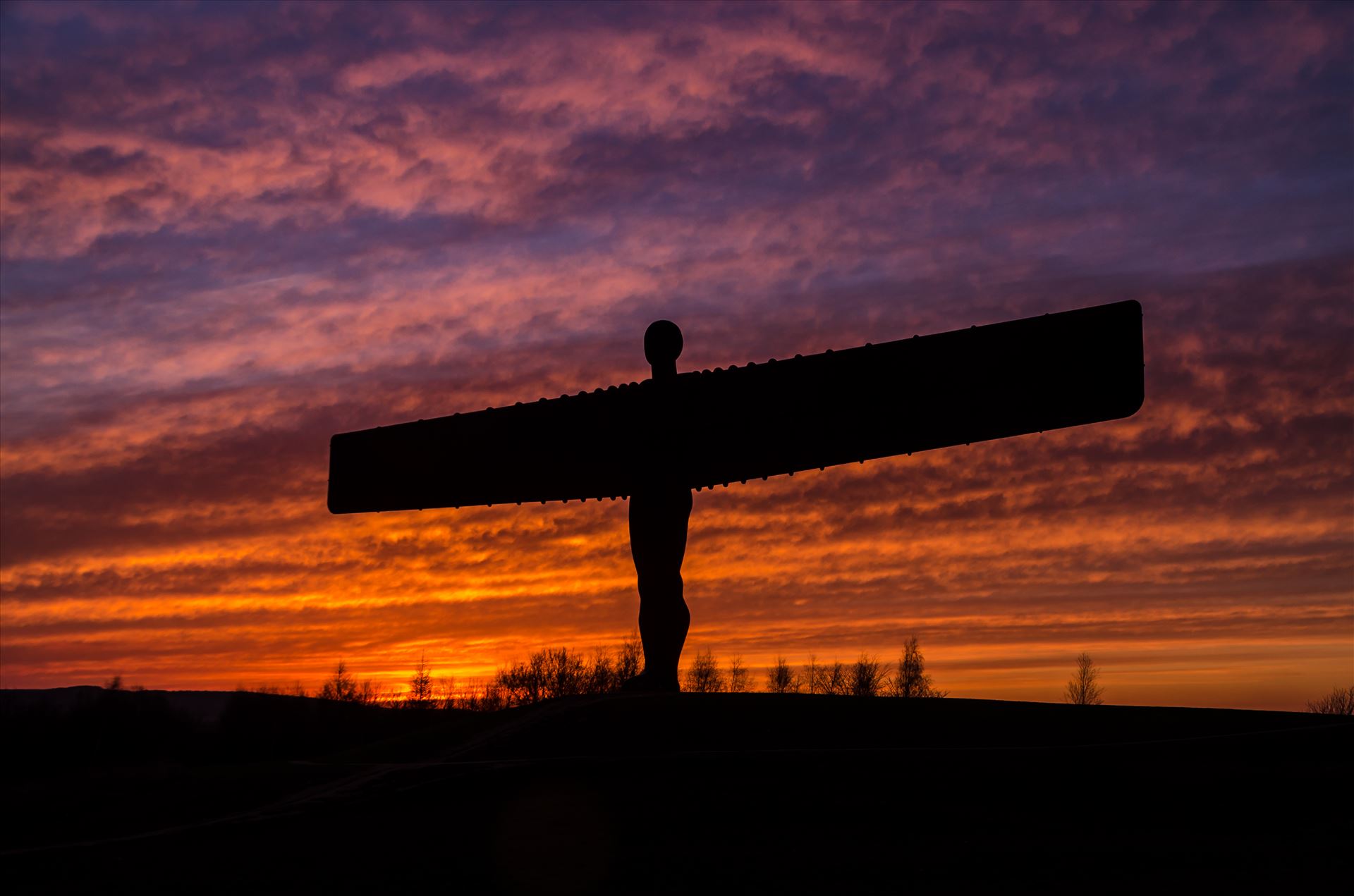 The Angel of the North at sunset - The Angel of the North is a contemporary sculpture, designed by Antony Gormley, located in Gateshead,  England.Completed in 1998, it is a steel sculpture of an angel, 20 metres (66 ft) tall, with wings measuring 54 metres (177 ft) across. by philreay